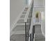 A well-lit staircase with carpeted steps and a modern metal railing leading to the upper level at 1084 Village Rd, Stone Mountain, GA 30088