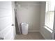 Small laundry room with shelving, ironing board, and hamper at 1625 Zara Ln, Stockbridge, GA 30281