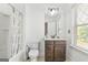 Bright bathroom featuring a shower-tub combo, a toilet, and a dark brown vanity with a white countertop at 6510 Bentley Ridge Dr, Cumming, GA 30040