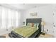 Cozy bedroom with a tufted headboard, soft carpet, natural light, and a minimalist decor at 6510 Bentley Ridge Dr, Cumming, GA 30040