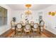Elegant dining room with a decorative chandelier, seating for eight, and a large window with natural light at 6510 Bentley Ridge Dr, Cumming, GA 30040