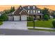 Charming two-story home with a three-car garage, brick facade, dormer windows, and beautifully landscaped front yard at 6510 Bentley Ridge Dr, Cumming, GA 30040
