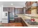 Well-equipped kitchen with stainless steel appliances, granite countertops, and dark wood cabinetry at 6510 Bentley Ridge Dr, Cumming, GA 30040