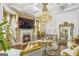 Elegant living room featuring a stone fireplace, hardwood floors, coffered ceilings, and a grand chandelier at 6510 Bentley Ridge Dr, Cumming, GA 30040