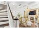 Bright and open living area featuring hardwood floors, stone fireplace, grand chandelier, and a staircase to the upper level at 6510 Bentley Ridge Dr, Cumming, GA 30040