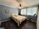 Cozy bedroom with a floral bedspread, ceiling fan, and a large window at 2606 Ramblewood Ct, Acworth, GA 30102