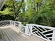 Spacious wood deck features white railings, offering picturesque view of lush greenery and landscaping at 2606 Ramblewood Ct, Acworth, GA 30102