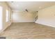 Spacious living room with wood-look flooring, large windows, and a staircase, creating an inviting atmosphere at 189 Orwell Dr # 47, Social Circle, GA 30025