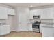 Cozy kitchen area with white cabinets, stainless appliances, and granite countertops at 271 Orwell Dr # 49, Social Circle, GA 30025