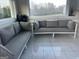Enclosed back porch area furnished with comfortable seating and sliding door access to the outside at 25 Franklin Way, Covington, GA 30016