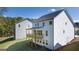 Exterior rear of the white home with a wooden deck and green lawn, showcasing outdoor living spaces at 1678 Lacebark Elm Way, Lawrenceville, GA 30045
