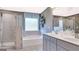 A luxurious bathroom featuring a separate glass shower, soaking tub, and gray tiled floor at 1678 Lacebark Elm Way, Lawrenceville, GA 30045