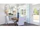 Bright dining area featuring an oval table, striped chairs, stylish decor, and access to the outdoors at 1678 Lacebark Elm Way, Lawrenceville, GA 30045