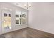 Bright dining room with hardwood floors, a modern chandelier, and a door leading to the back patio at 1678 Lacebark Elm Way, Lawrenceville, GA 30045