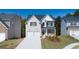 Charming two-story home featuring a brick facade, two-car garage and inviting front porch at 1678 Lacebark Elm Way, Lawrenceville, GA 30045