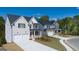 New construction home with a two-car garage, covered front porch, and manicured lawn in a suburban neighborhood at 1678 Lacebark Elm Way, Lawrenceville, GA 30045