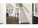 Bright foyer with hardwood floors, staircase, and view into the living and dining areas of the home at 1678 Lacebark Elm Way, Lawrenceville, GA 30045