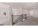 Upstairs hallway with carpet flooring, wood and metal railings, and views into other rooms of the home at 1678 Lacebark Elm Way, Lawrenceville, GA 30045