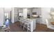 Open kitchen with granite countertops, stainless steel appliances, a central island, and hardwood floors at 1678 Lacebark Elm Way, Lawrenceville, GA 30045