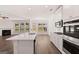 Modern kitchen with stainless appliances, an island, and an adjacent living space at 1678 Lacebark Elm Way, Lawrenceville, GA 30045