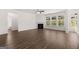 Open-concept living room with hardwood floors, fireplace, and large windows overlooking the backyard at 1678 Lacebark Elm Way, Lawrenceville, GA 30045