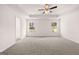Spacious carpeted primary bedroom with a tray ceiling, ceiling fan, and large windows for natural light at 1678 Lacebark Elm Way, Lawrenceville, GA 30045