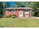 Charming brick home featuring well-maintained landscaping, black shutters, and a welcoming front entrance at 6671 Pelica Ct, Riverdale, GA 30274