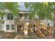 Home's rear view, featuring an elevated wooden deck and stone tile patio below at 3192 Creek W Trce, Powder Springs, GA 30127