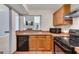 Kitchen features wood cabinets, black appliances, and a view into the living room at 4234 Stillwater Dr, Duluth, GA 30096