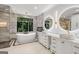 Elegant bathroom with a freestanding tub, double vanity, and large mirrors at 3946 Paces Ferry Nw Rd, Atlanta, GA 30327