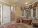 Spa-like bathroom with copper tub, walk-in shower, and elegant tile at 2554 Emerald Dr, Jonesboro, GA 30236