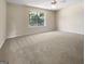 Spacious bedroom with neutral carpeting, a ceiling fan, and a large window at 9997 Point View Dr, Jonesboro, GA 30238