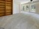 Spacious living room featuring built-in shelves, large windows, and neutral carpeting at 9997 Point View Dr, Jonesboro, GA 30238