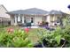 View of backyard with patio, seating, and flowers, from behind flowering bushes in the grass at 121 Pinnacle Ln, Mcdonough, GA 30253