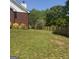 A backyard featuring a newly constructed wooden fence, grass, and the corner of a brick house at 825 S Bethany Rd, Locust Grove, GA 30248
