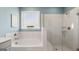 Bathroom with soaking tub, glass shower, and marble tile at 568 Parnassus Rd, Locust Grove, GA 30248