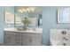 Double vanity bathroom with light blue walls and a tub at 568 Parnassus Rd, Locust Grove, GA 30248