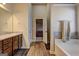 Bathroom showcasing a double vanity, soaking tub, and wood-look tile floor at 1223 Hartwell Rd, Locust Grove, GA 30248