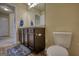 Clean bathroom with dark brown vanity, toilet, and view into the hallway at 1223 Hartwell Rd, Locust Grove, GA 30248