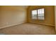 This carpeted bedroom has tan walls, a large window, and a vaulted ceiling at 1223 Hartwell Rd, Locust Grove, GA 30248