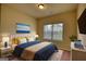 Well-lit bedroom with blue accents, a comfortable bed, and a picturesque landscape painting at 1223 Hartwell Rd, Locust Grove, GA 30248