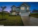 Two-story light blue house with a two-car garage and front yard at dusk at 1168 Bodega Loop, Locust Grove, GA 30248