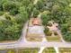 Aerial view of property featuring a home, outbuilding, ample parking, and tree-lined boundaries at 1352 E Atlanta Rd, Stockbridge, GA 30281