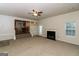 Spacious living room with a fireplace, ceiling fan, and a view into the kitchen at 137 Legend Creek Dr, Canton, GA 30114