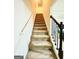 Elegant staircase with neutral carpeting and dark wood railing at 20 Streamside Dr, Covington, GA 30016