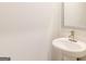 Elegant powder room featuring a pedestal sink, modern faucet, and a sleek framed mirror at 180 Weldon Rd # 21, Mcdonough, GA 30253