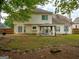Back yard view featuring a covered entertainment area and mature trees at 2560 Almont Way, Roswell, GA 30076