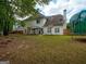 Spacious backyard showcasing a covered patio, ample green space, and a secure fence for privacy at 2560 Almont Way, Roswell, GA 30076