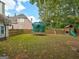 Expansive backyard featuring a trampoline and playset, perfect for outdoor activities and Gathering fun at 2560 Almont Way, Roswell, GA 30076
