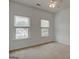 This empty bedroom features carpet floors and two windows at 2560 Almont Way, Roswell, GA 30076
